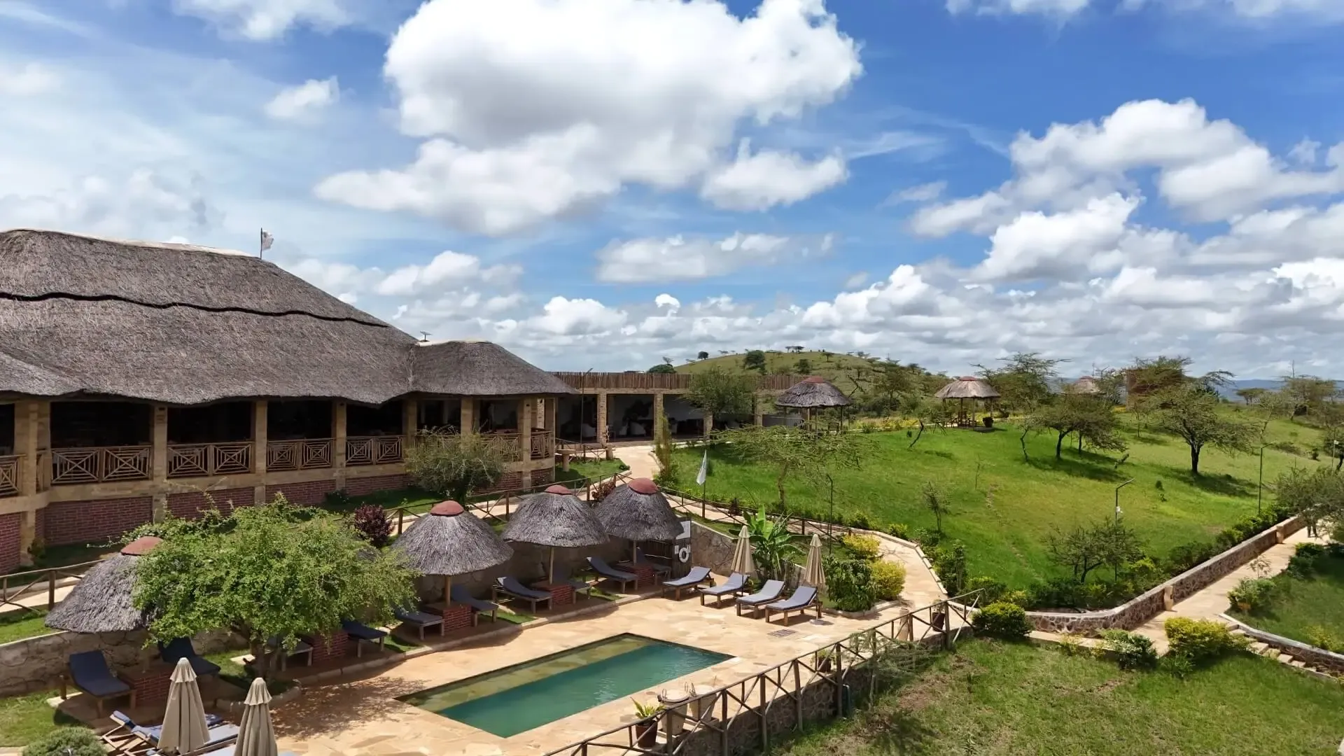 Thatched lodge buildings and gardens at Africa Safari Karatu