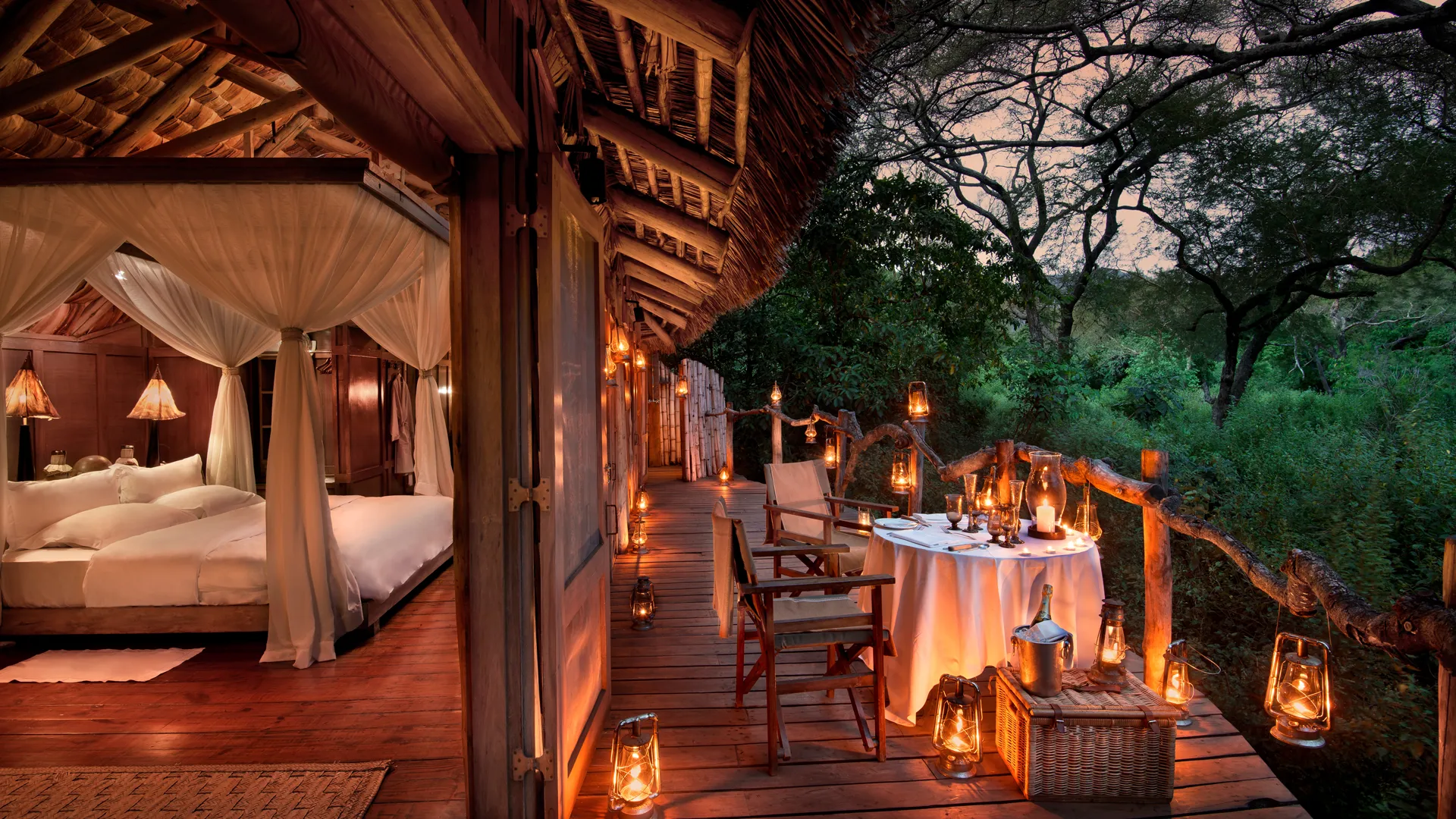 Private deck set for dinner by lantern light at a Lake Manyara Tree Lodge suite