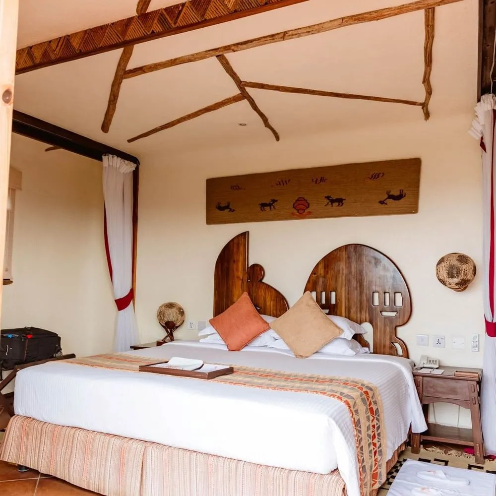 Guest room with carved headboard at Serengeti Serena Safari Lodge